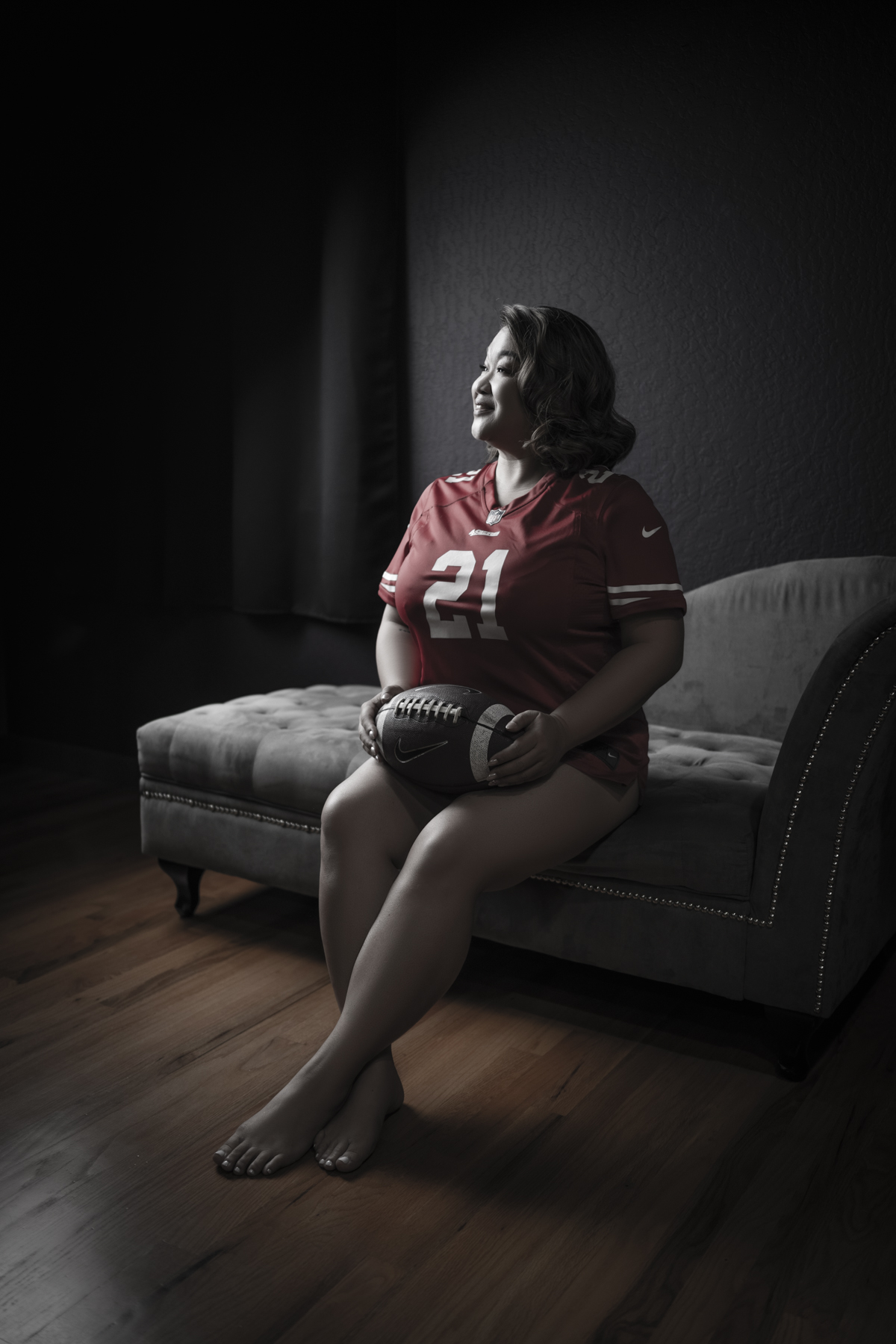Portrait of a woman in a football jersey on a chaise