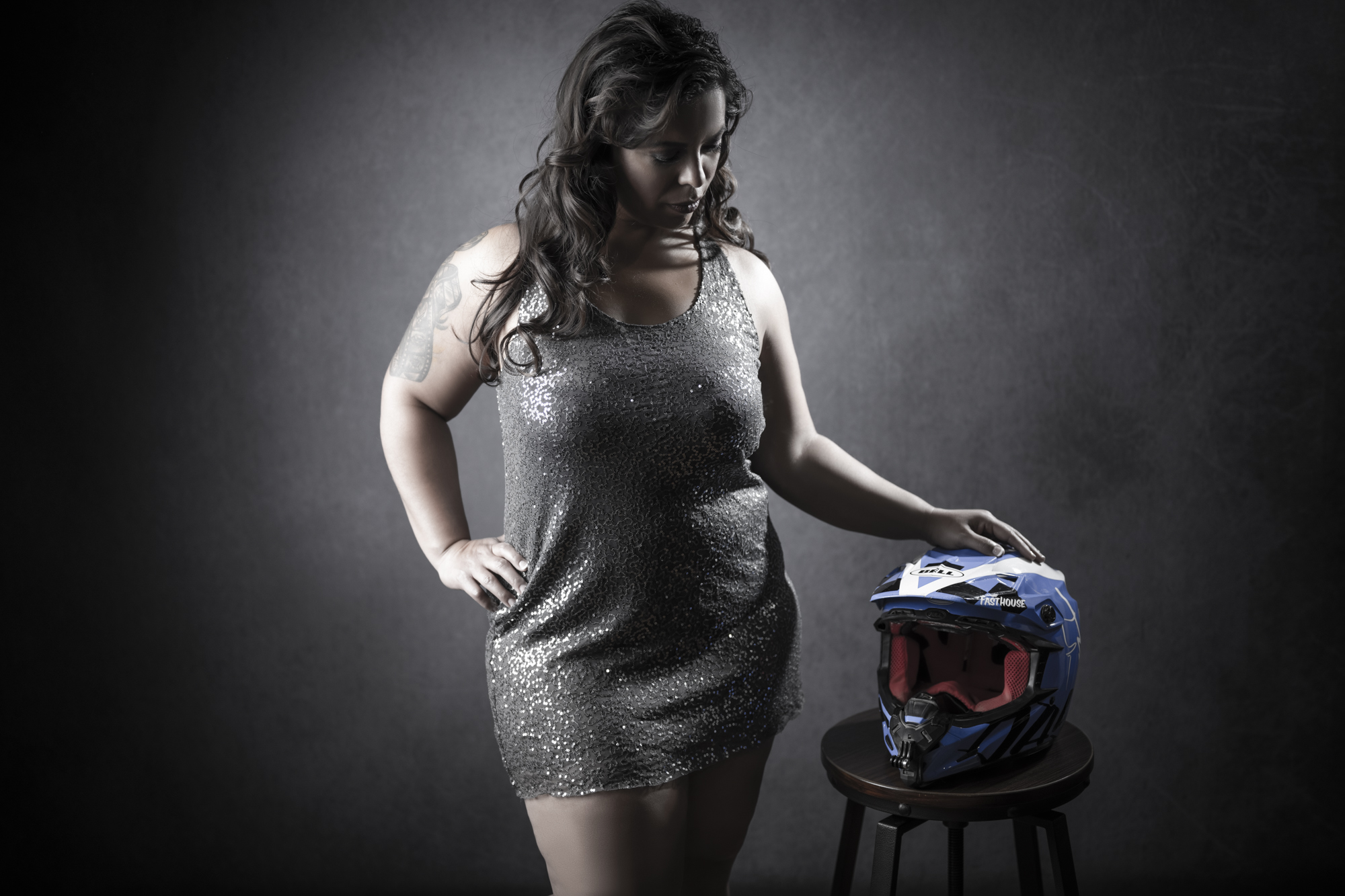 Portrait of a woman in a sequin dress with a motocross helmet