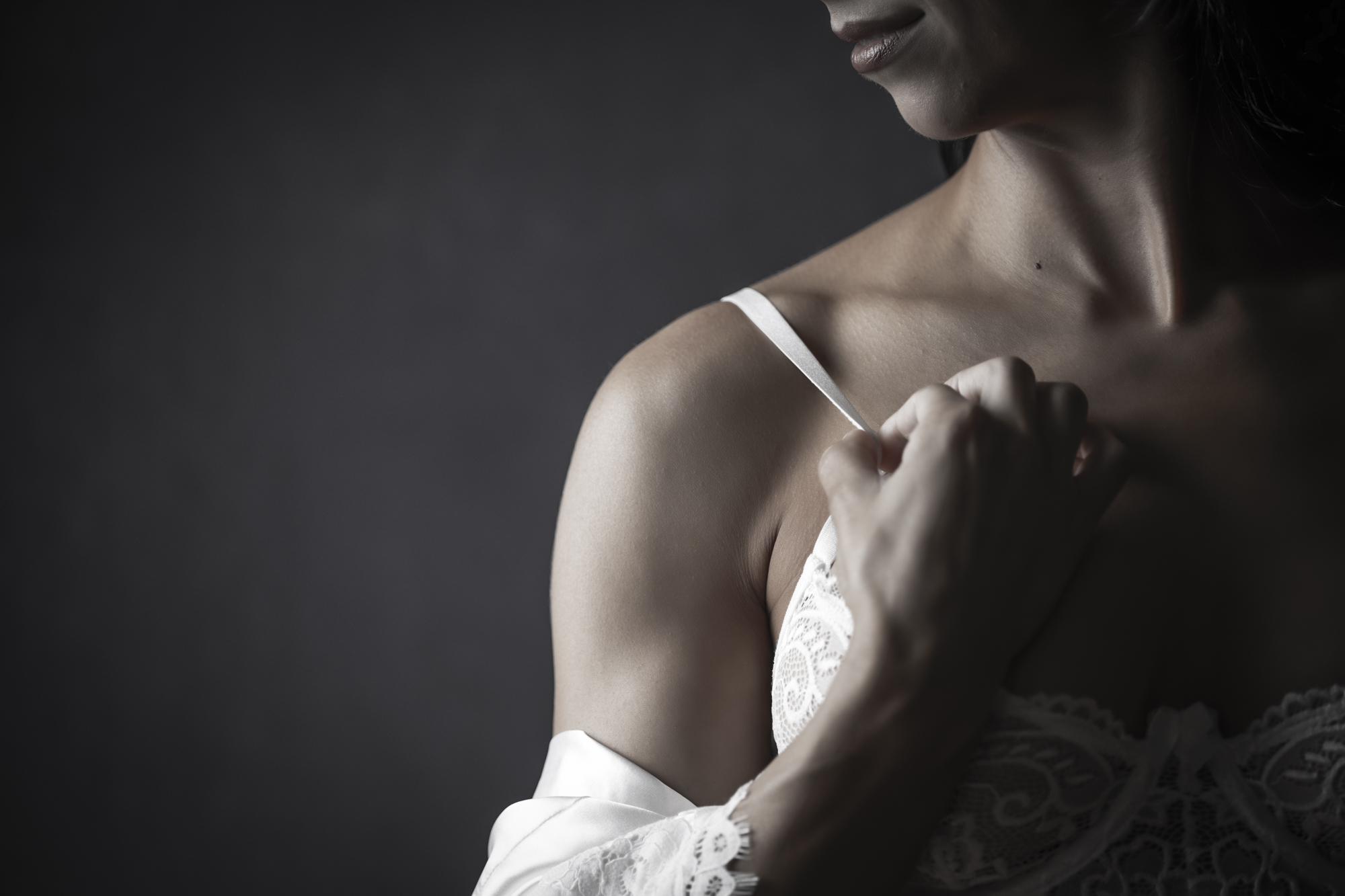 Detail portrait of a shoulder and white lace strap