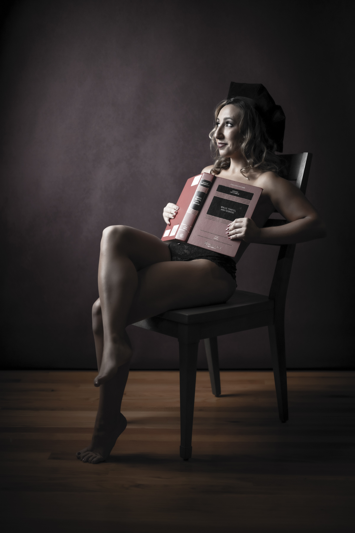 Playful portrait of a woman seated with law books